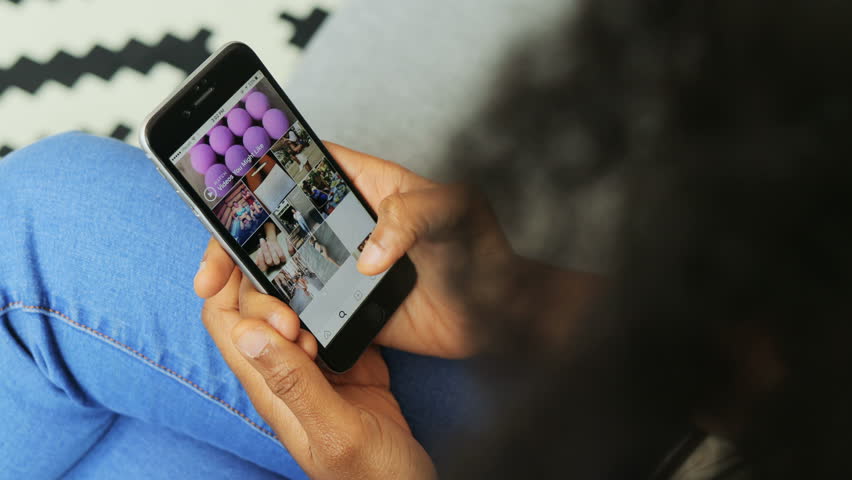 African American woman searching Instagram app on phone